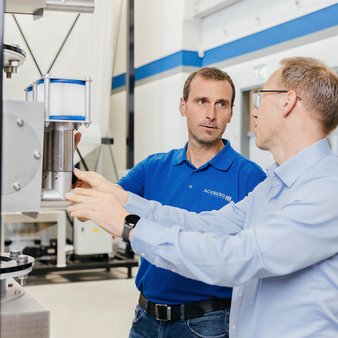 Zwei unserer Experten im technischen Austausch, direkt an einem unserer Absaugkästen.